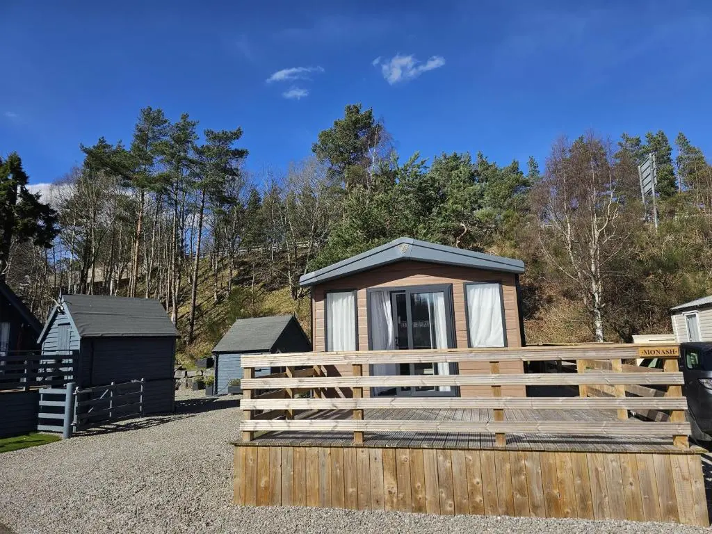 a tiny house behind a wooden fence at Monash in Aviemore