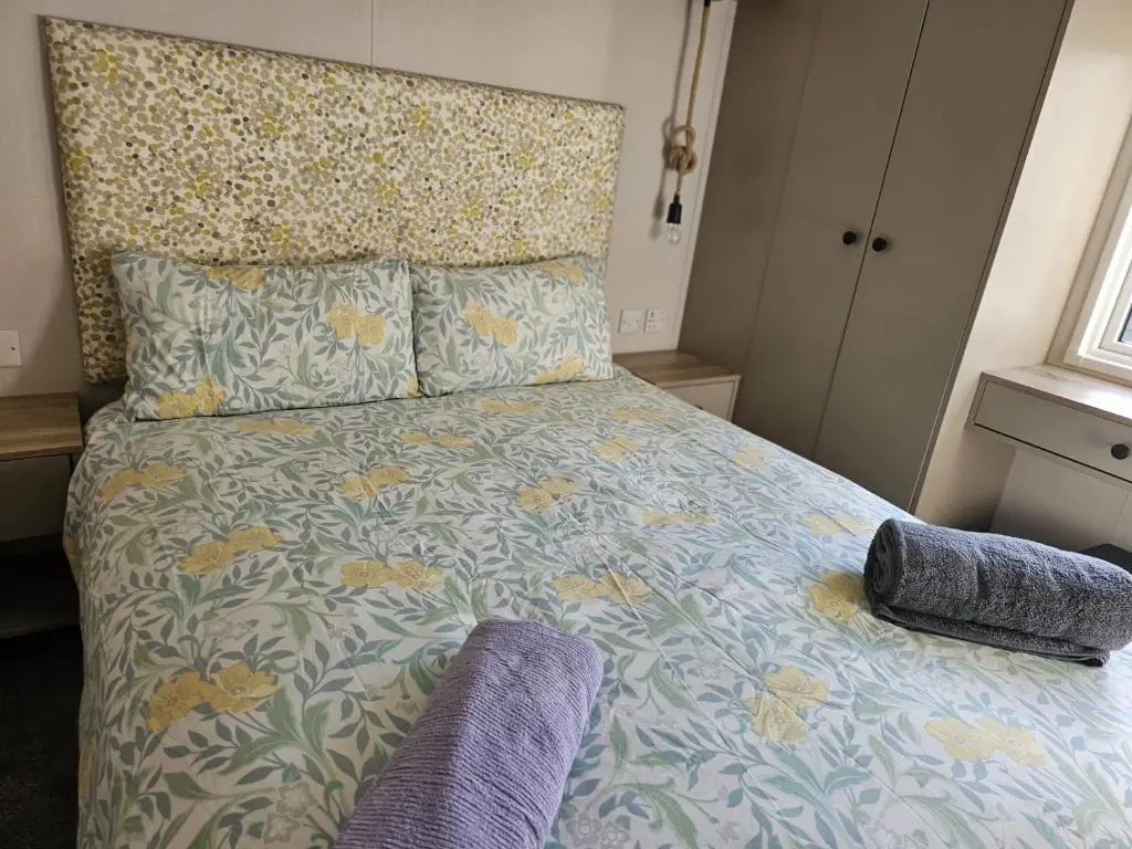 a bedroom with a bed with a floral bedspread at Monash in Aviemore
