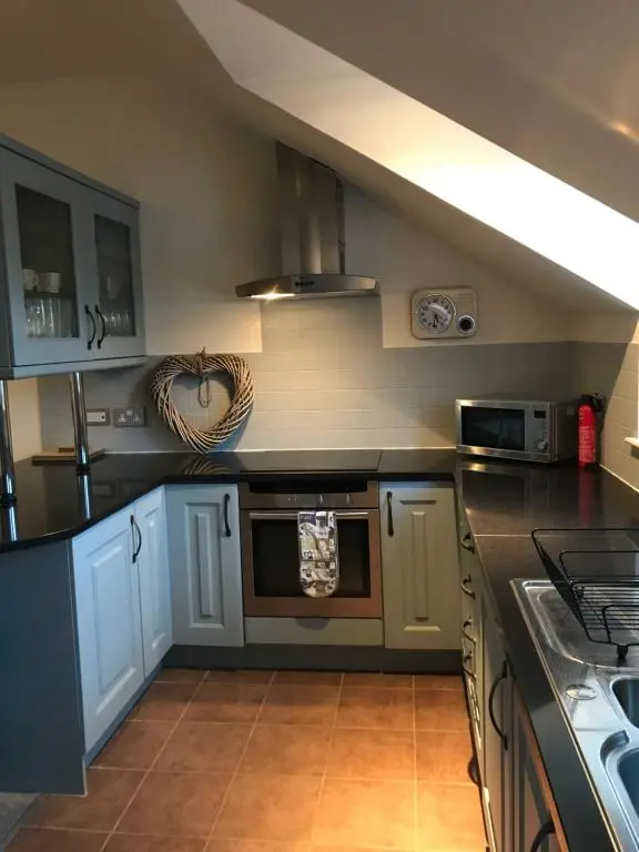 a kitchen with blue cabinets and a stove top oven at The Town House in Dornoch