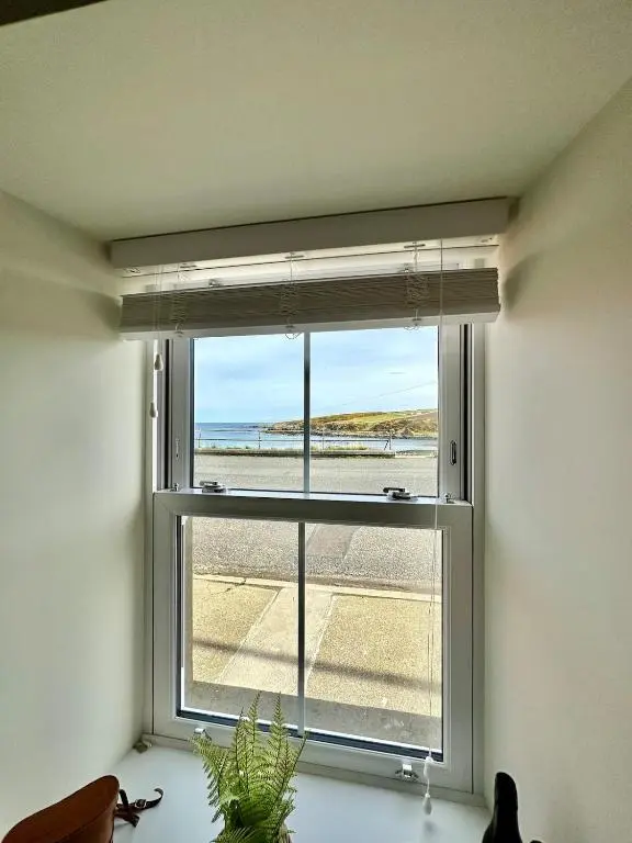 a window in a room with a view of the beach at Luxury Coastal Cottage in Portsoy