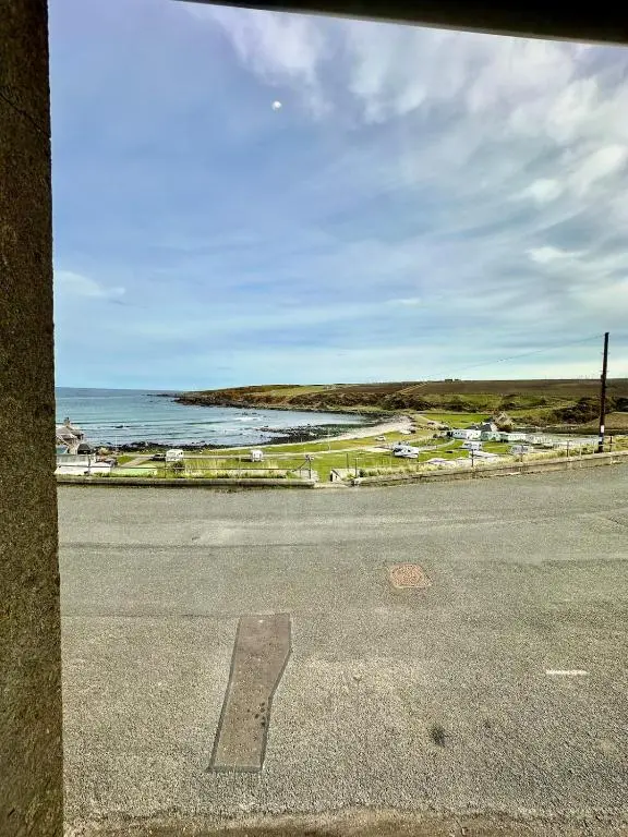 an empty street with a view of the ocean at Luxury Coastal Cottage in Portsoy