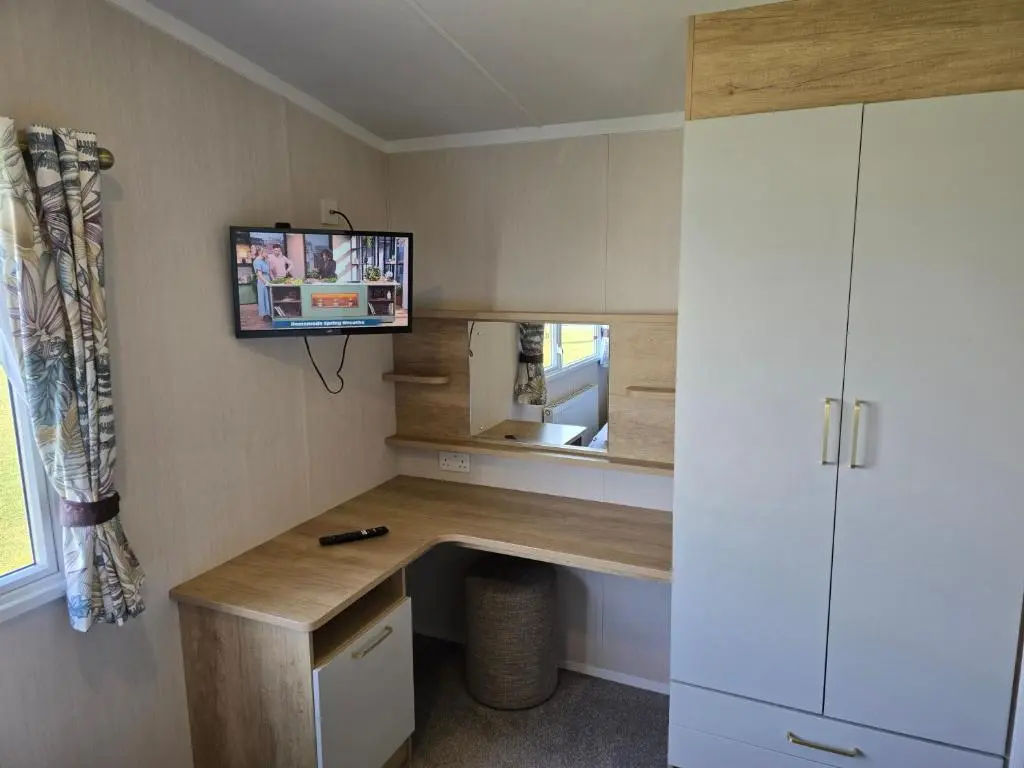 a small room with a desk and a television at 3 Bed-Sleeps 8-Free Parking-5 Min to Beach in Dornoch