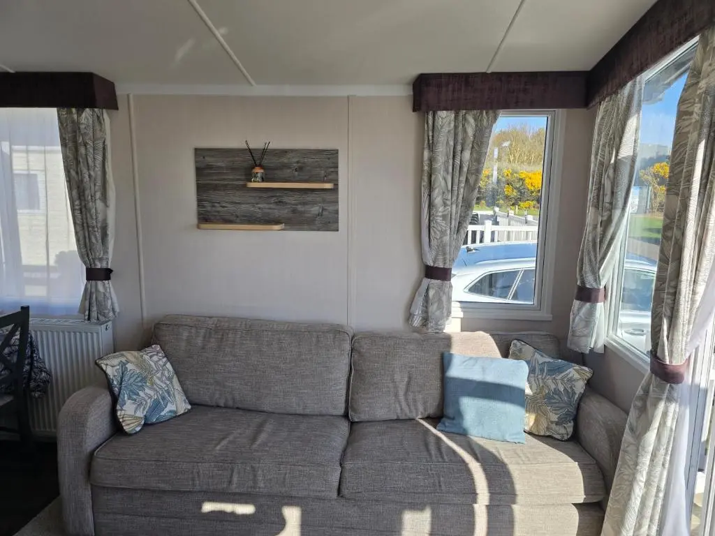 a living room with a couch and a window at 3 Bed-Sleeps 8-Free Parking-5 Min to Beach in Dornoch