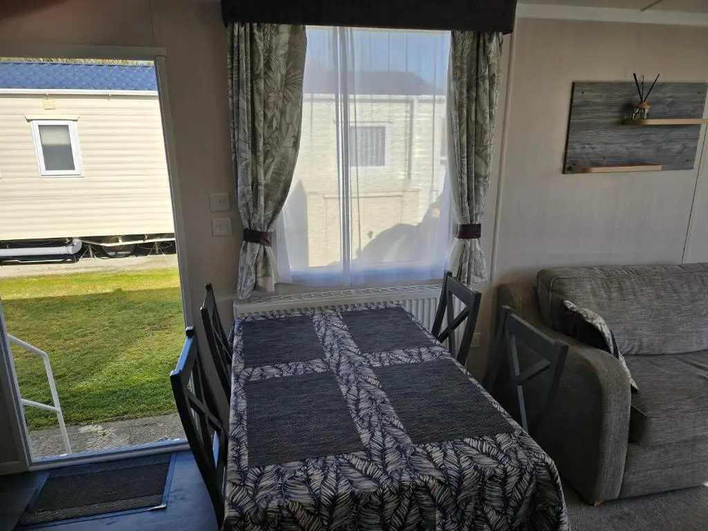 a bedroom with a table and a bed and a window at 3 Bed-Sleeps 8-Free Parking-5 Min to Beach in Dornoch