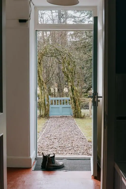 a door leading into a yard with shoes outside at Gamekeeper's Cottage in Banchory