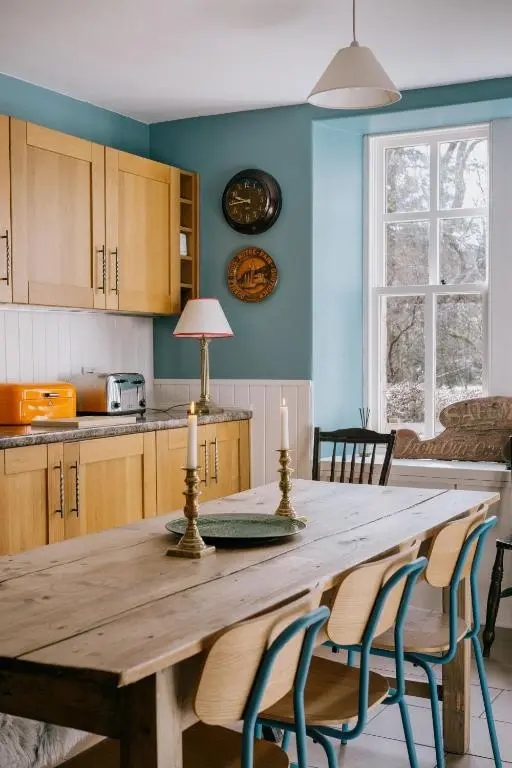 a kitchen with a wooden table with two candles on it at Gamekeeper's Cottage in Banchory