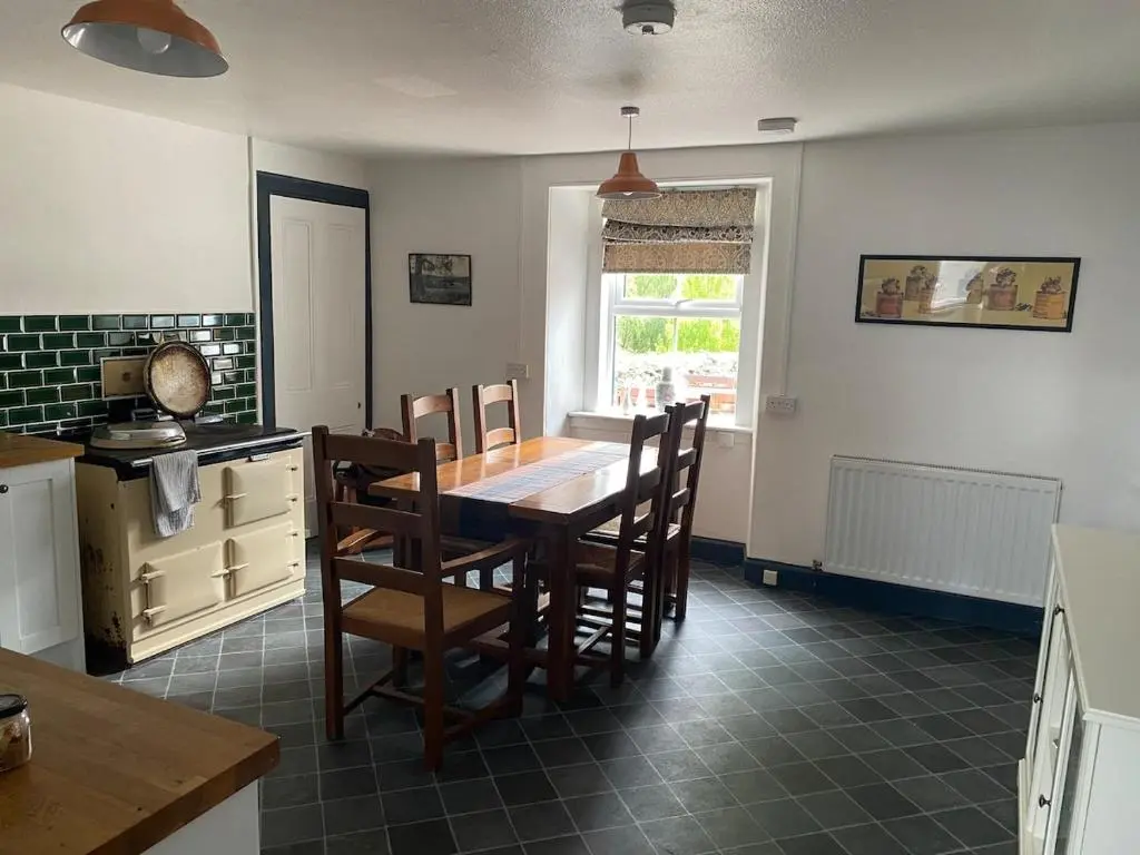 a kitchen with a table and chairs in a kitchen at The old Farmhouse Minutes from lochness in Drumnadrochit