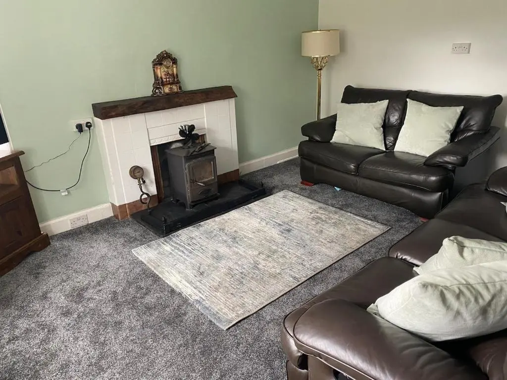 a living room with a couch and a fireplace at The old Farmhouse Minutes from lochness in Drumnadrochit