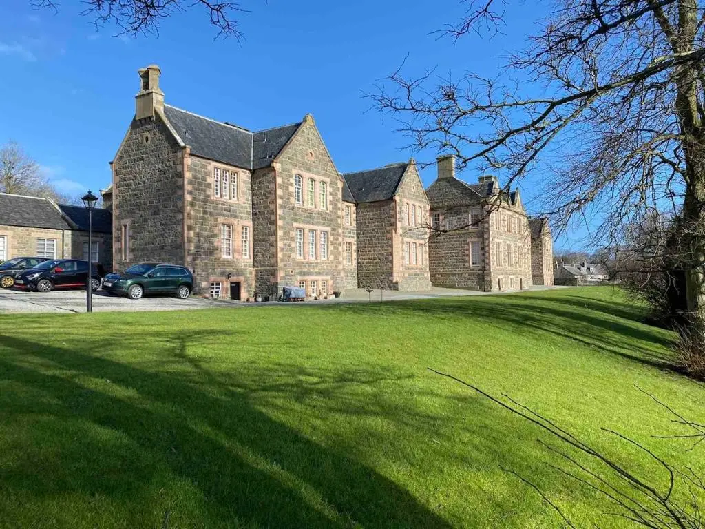 a large brick building with a green lawn in front of it at 2 bedroom Townhouse within Grade C listed Ladysbridge House 2 night minimum stay in Ladysbridge Station