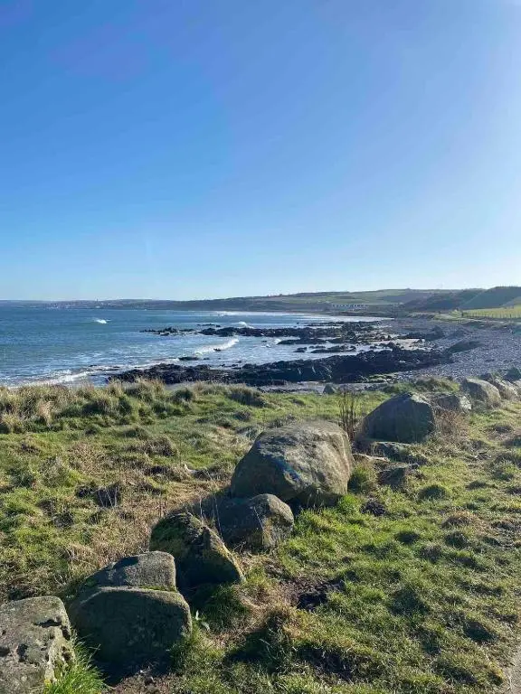 a group of rocks on a field with the ocean at 2 bedroom Townhouse within Grade C listed Ladysbridge House 2 night minimum stay in Ladysbridge Station
