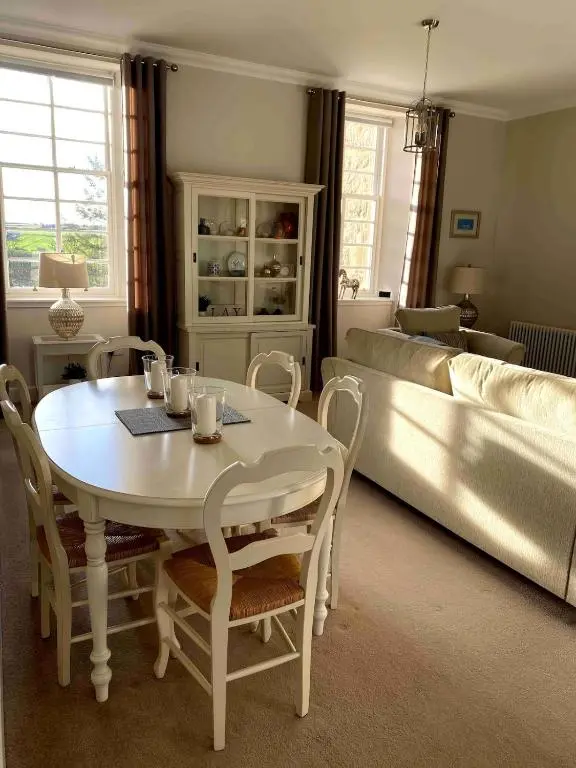 a living room with a table and a couch at 2 bedroom Townhouse within Grade C listed Ladysbridge House 2 night minimum stay in Ladysbridge Station