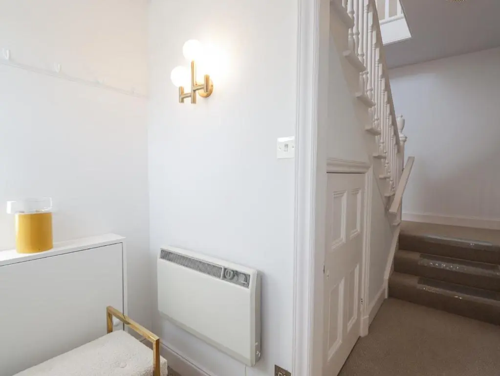 a hallway with a staircase with a cross on the wall at Aspen Spa Apartment in Dornoch