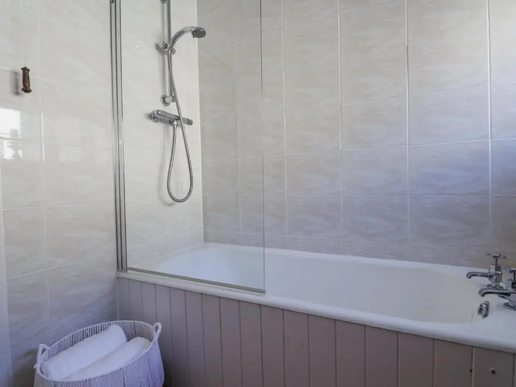 a bathroom with a shower and a bath tub at Aspen Spa Apartment in Dornoch