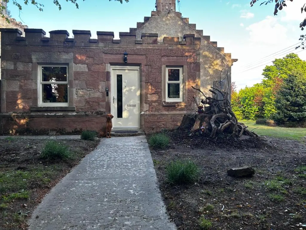 a brick house with a white door and a sidewalk at Clashmore House Garden Cottage Dornoch in Dornoch