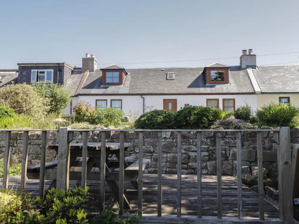 a wooden fence in front of a house at Fishers Cottage in Inverness