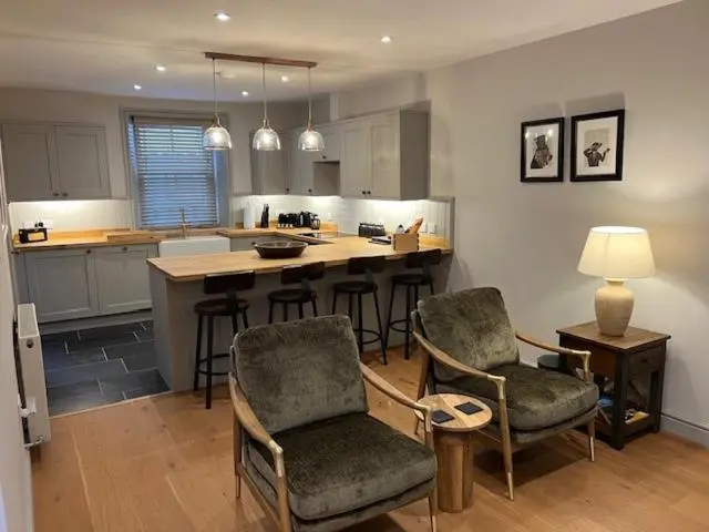 a kitchen with a island with chairs and a table at Balnain Street Cottage in Inverness