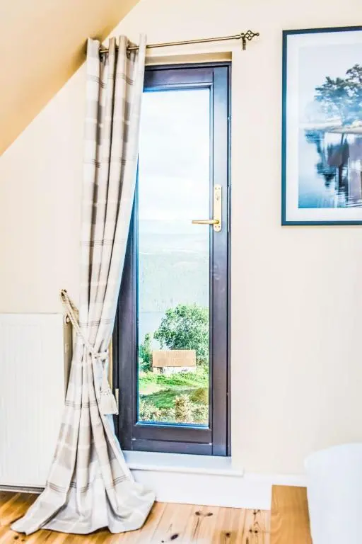 a window in a room with a curtain at Villa Drover's Lodge by Interhome in Drumnadrochit
