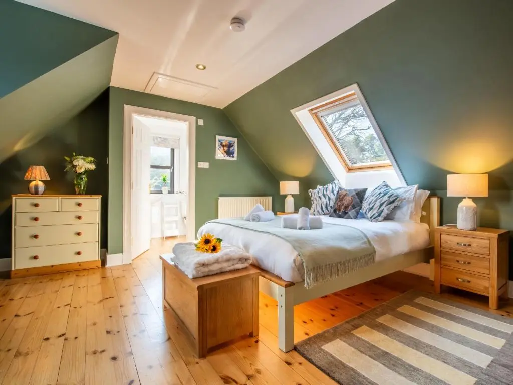 a bedroom with a large bed and green walls at Villa Drover's Lodge by Interhome in Drumnadrochit