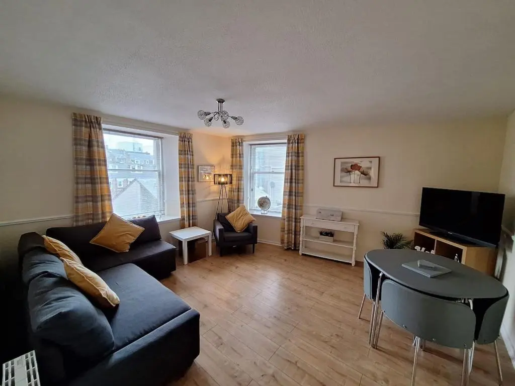 a living room with a couch and a table at Inverness City Centre Apartment! in Inverness