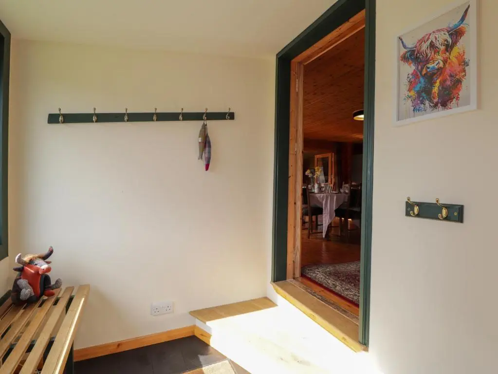 a room with a door leading into a dining room at The Lodge in Beauly