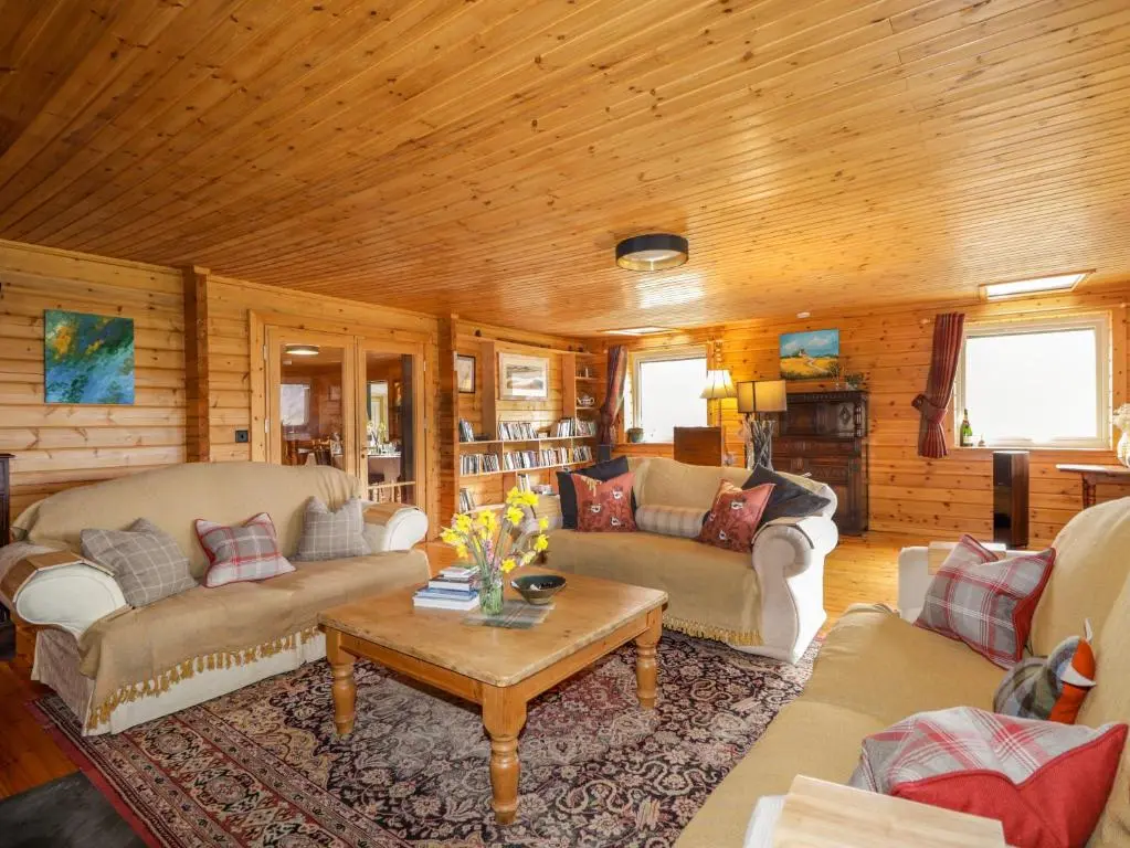 a living room with couches and a table at The Lodge in Beauly