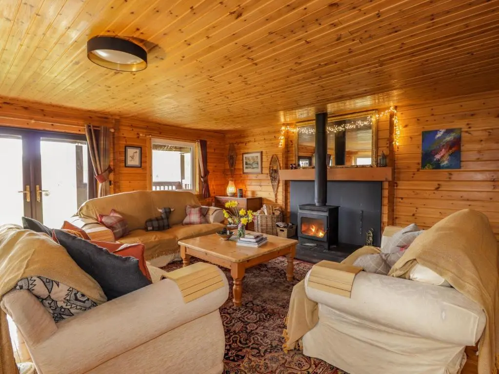 a living room with two couches and a fireplace at The Lodge in Beauly