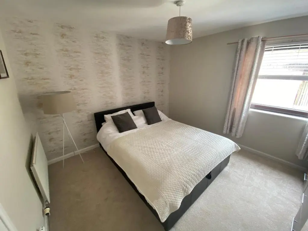 a bedroom with a bed and a window at Impala Apartment in Wick