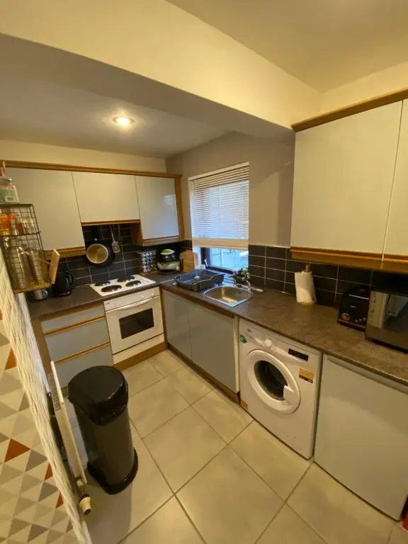 a kitchen with a washing machine in the middle at Impala Apartment in Wick