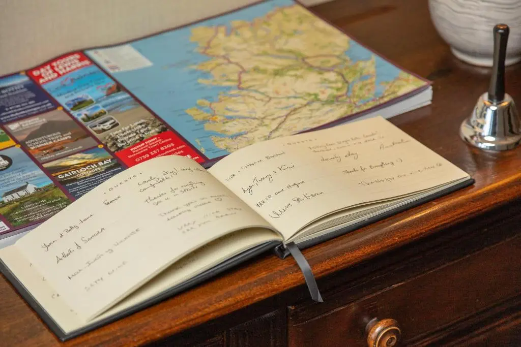 an open book on a table with a map at Old Surgery Guest House in Ullapool