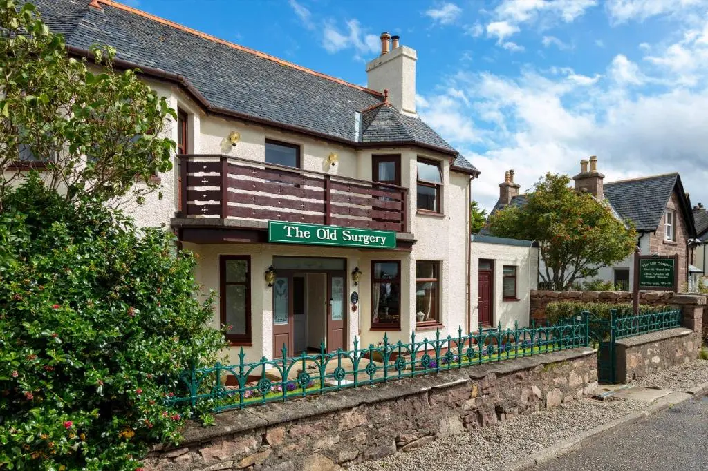 a building with a sign that reads the oil survey at Old Surgery Guest House in Ullapool
