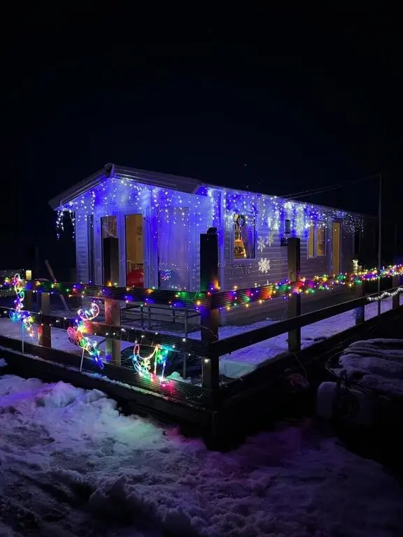 a house covered in christmas lights and lights at Woodend Caravan in Shinness