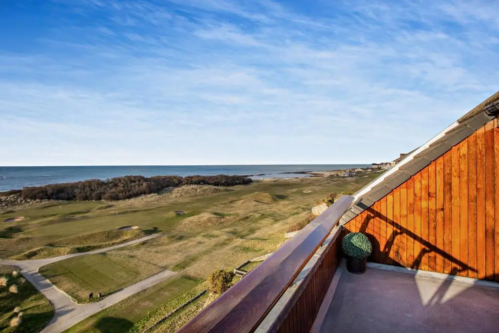 a view of the ocean from the balcony of a house at Penthouse Golf View Apartments in Lossiemouth