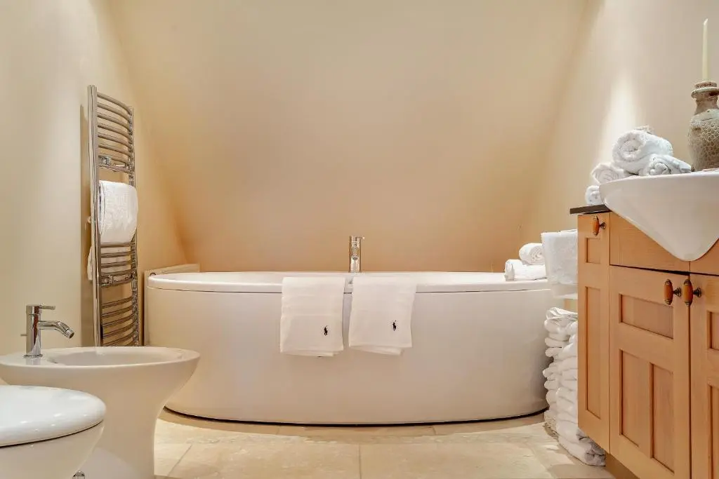 a bathroom with a tub and a toilet and a sink at Penthouse Golf View Apartments in Lossiemouth