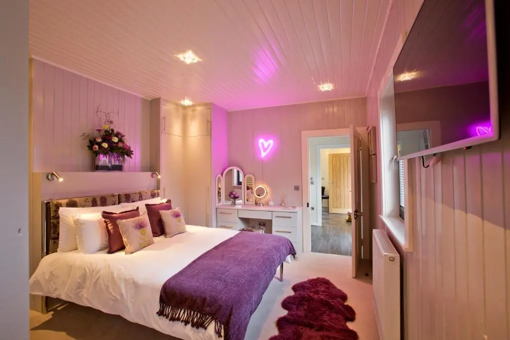 a bedroom with a bed with purple lighting at The Invergarry - Royal Deeside Luxury 5 star Couples Retreat with Hot Tub, Aboyne in Aboyne