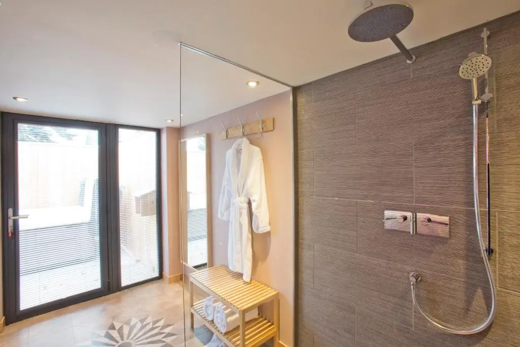 a bathroom with a walk in shower and a glass door at The Invergarry - Royal Deeside Luxury 5 star Couples Retreat with Hot Tub, Aboyne in Aboyne