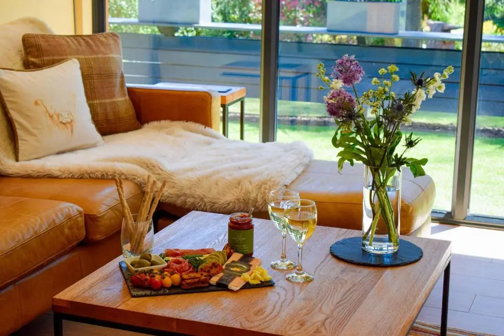 a coffee table with a tray of food and wine glasses at The Invergarry - Royal Deeside Luxury 5 star Couples Retreat with Hot Tub, Aboyne in Aboyne