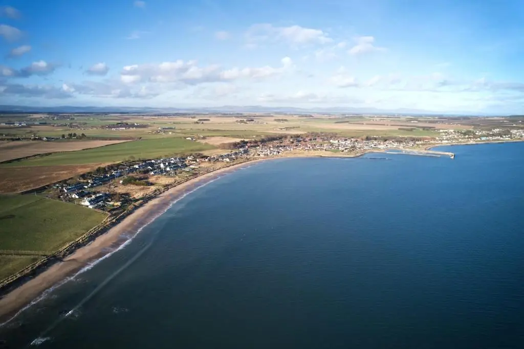 an aerial view of a beach and the ocean at Cosy fisherman cottage in seaside village in Shandwick