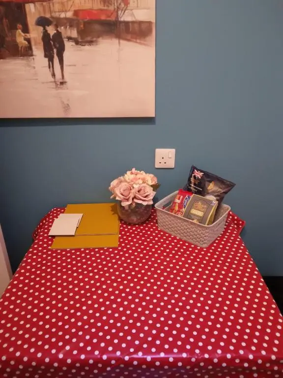 a table with a red and white polka dot table cloth at Cosy central 1 bedroom apartment, free parking in Inverness