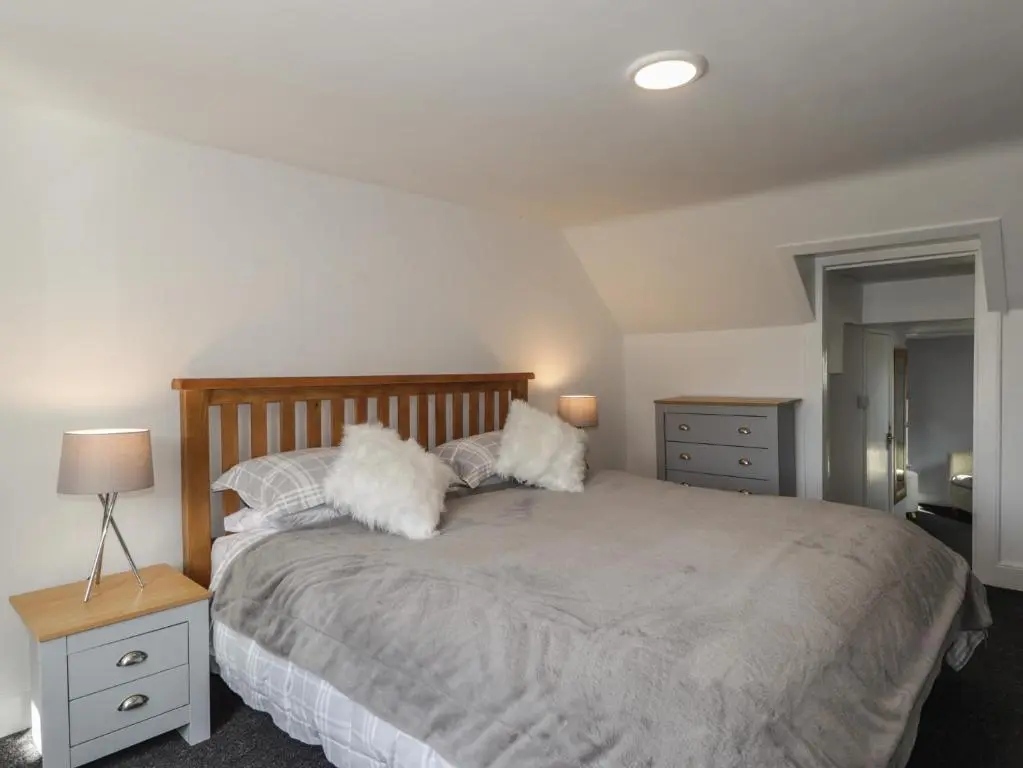 a bedroom with a large bed with pillows on it at 6 New Street in Elgin