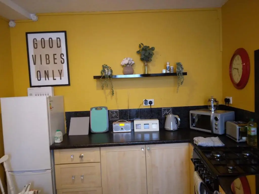 a kitchen with a black counter top with a refrigerator at Cosy central 2 bedroom apartment - free parking in Inverness