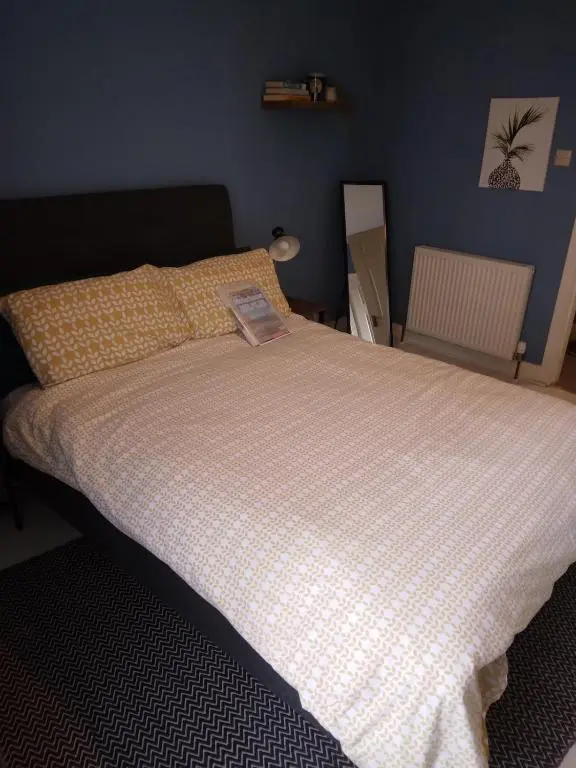 a bed with a book on it in a bedroom at Cosy central 2 bedroom apartment - free parking in Inverness