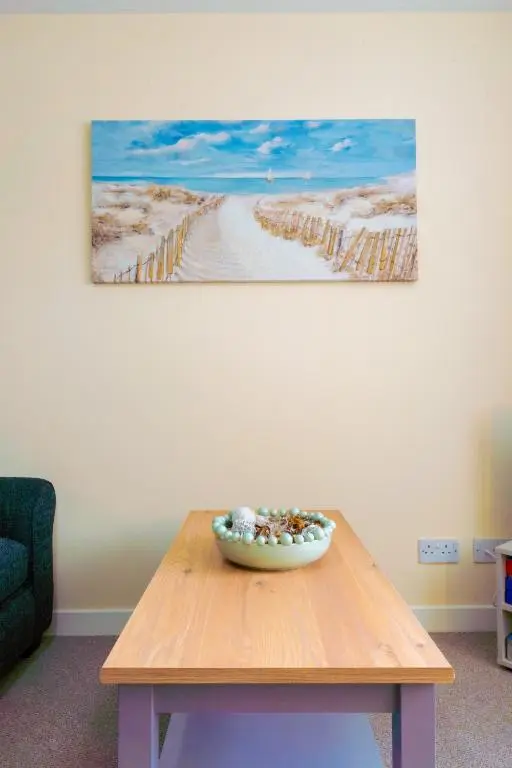 a wooden table with a bowl on top of it at Lovely & Bright 2 Bed Apartment in Inverness