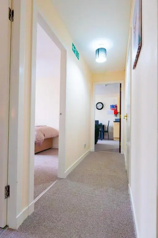 a hallway leading to a bedroom with a bed at Lovely & Bright 2 Bed Apartment in Inverness