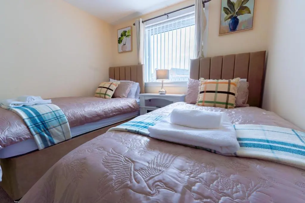 a bedroom with two beds and a window at Lovely & Bright 2 Bed Apartment in Inverness