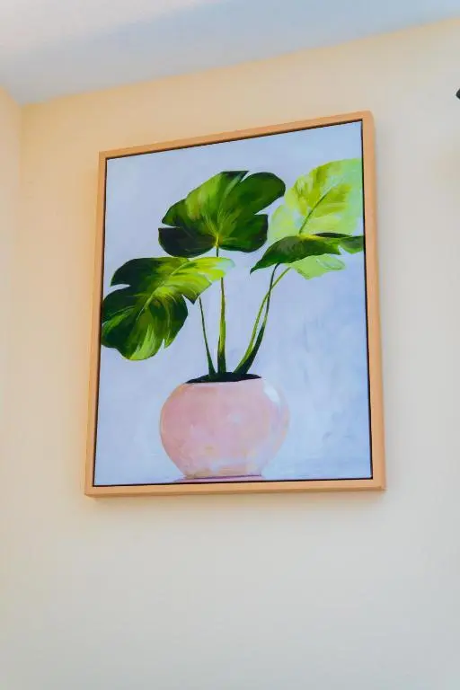 a painting of a plant in a pink vase on a wall at Lovely & Bright 2 Bed Apartment in Inverness