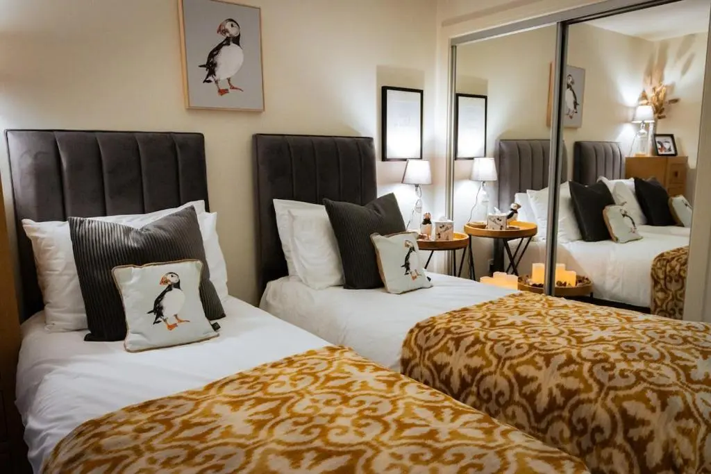 a hotel room with two beds and a mirror at Luxury Apartment Alford Aberdeenshire in Alford