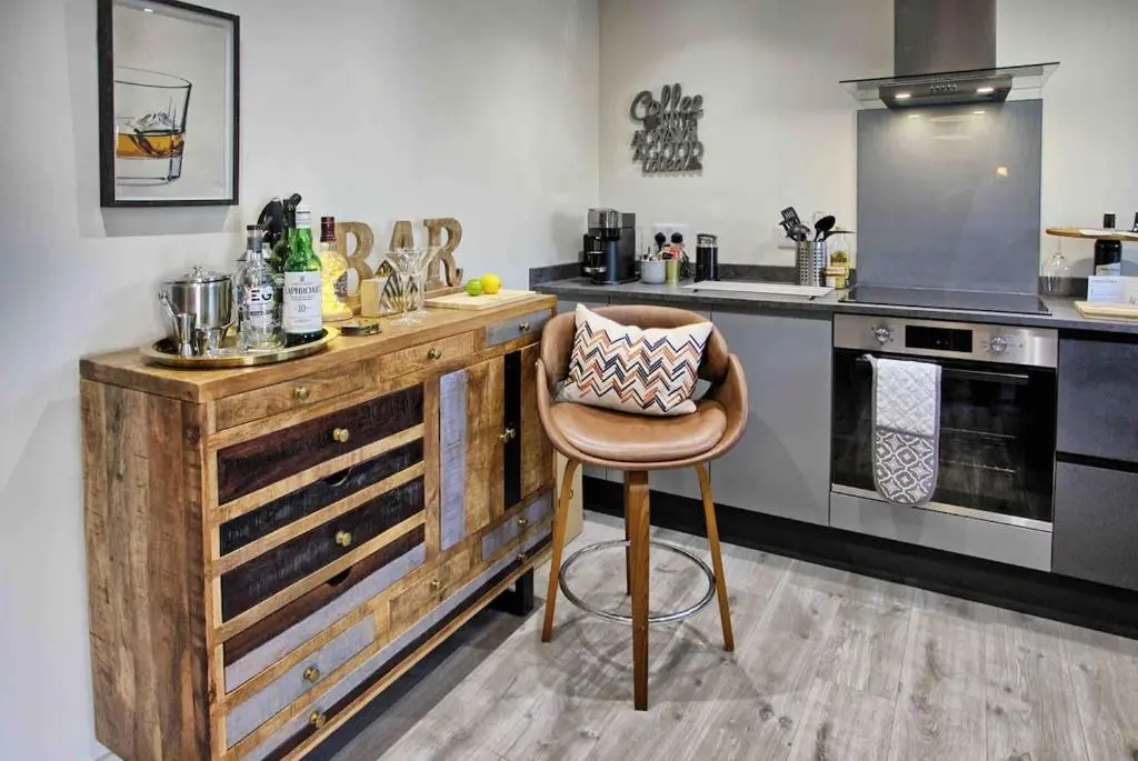 a kitchen with a wooden counter with a chair in it at Luxury Apartment Alford Aberdeenshire in Alford