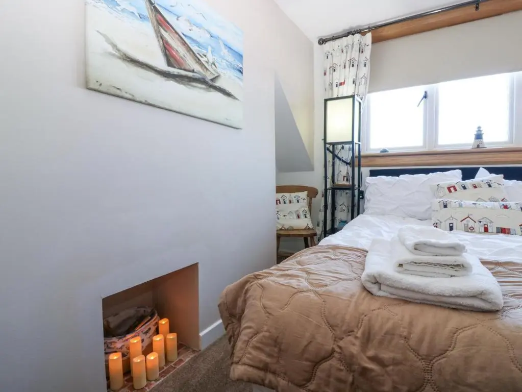 a bedroom with a bed with a fireplace at Periwinkle Cottage in Banff