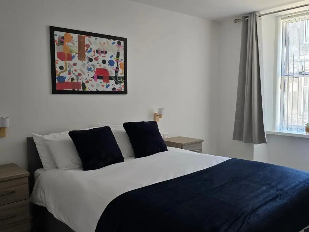 a bedroom with a bed and a picture on the wall at Nairn Nights in Nairn
