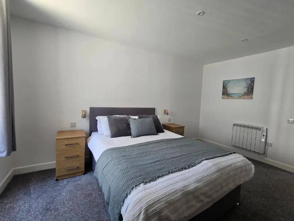 a bedroom with a large bed and a wooden dresser at Nairn Nights in Nairn